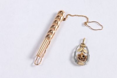 a pen and a pendant on a white surface