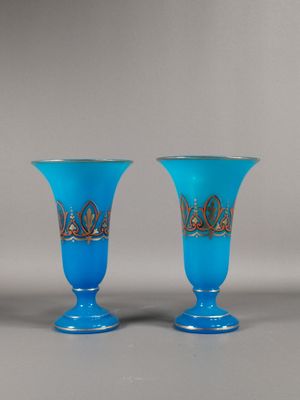 une paire de vases en verre bleu ornés de motifs dorés