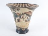 a vase that has a picture of a house on it
