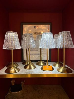 trois lampes posées sur une table, avec un tableau en arrière-plan