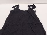 the top of a black shirt is laying on a white surface