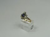 an image of a diamond and sapphire ring on a clear acrylic stand
