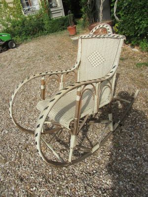 a rocking chair that is sitting in the gravel