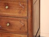 a vase with flowers on top of a wooden chest of drawers