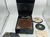 un vieux tourne-disque posé sur une table, à côté d'autres disques