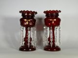 une paire de vases en verre rouge posés sur une table blanche