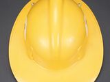 a yellow hard hat sitting on a gray surface