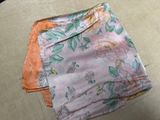 a pink and orange blanket on the floor next to a pair of scissors and a pair of scissors