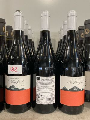 plusieurs bouteilles de vin rouge sont alignées sur un comptoir