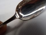a silver spoon with a spoon handle in the middle of it