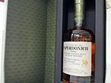 an open box with a bottle of whisky in it sitting on a table