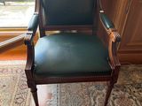 un fauteuil en cuir vert placé devant une fenêtre