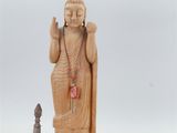 wooden statue of a person holding a knife next to other items