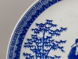 a blue and white plate with a picture of a man and a woman