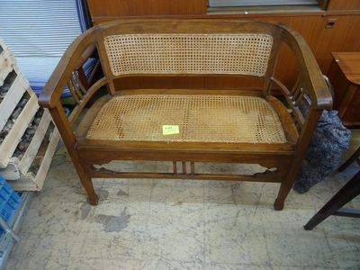 une chaise en bois avec une assise en osier dans une pièce