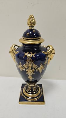 un vase bleu orné d'une décoration dorée