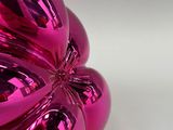a pink balloon shaped like a flower on a white surface