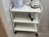 a small white shelf with a blender on top of it