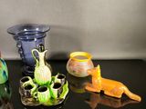 four different vases on a table with a black background
