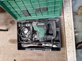 une boîte verte posée par terre, contenant des outils