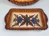 two decorative dishes sitting on a table next to each other