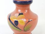 un petit vase sur lequel est peinte une fleur