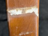 a close up of a wooden chair with peeling paint on it