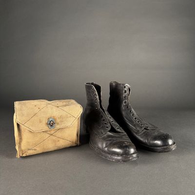 deux paires de bottes noires et un sac à main marron posés sur une surface grise