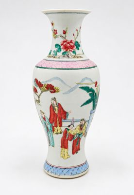 un vase blanc avec un tableau posé sur une table