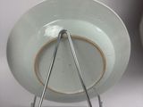 a green plate with a metal stand on a white table