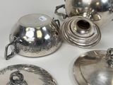 three silver teapots and a teapot on a white table