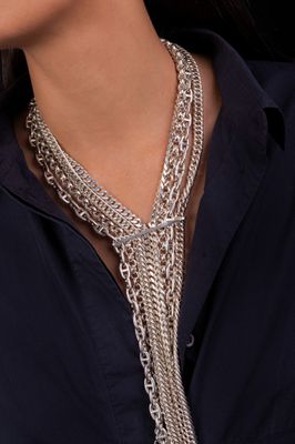 woman wearing a necklace and earrings with a chain around her neck