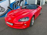 a picture of a red sports car parked in front of a building