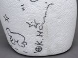 a close up of a white vase with writing on it