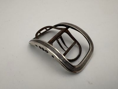 Boucle de chaussure en argent à décor de filets.