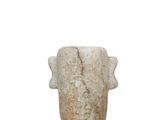 un vase en pierre posé sur une surface blanche