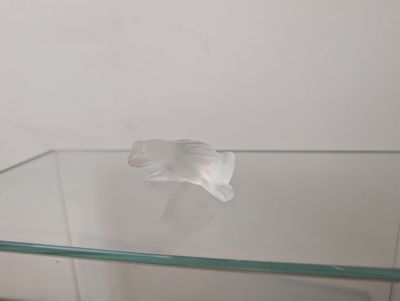 une table en verre sur laquelle est posée une fleur en verre