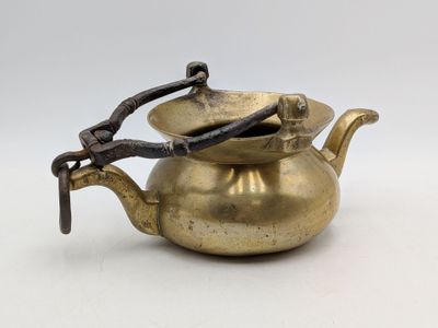an old brass teapot with a handle and a handle on it