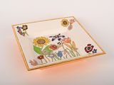 a plate with a flower design on it on a white surface