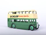 a green and yellow double decker bus on a white surface