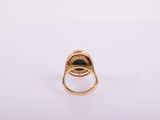 a close up of a gold ring with a black stone
