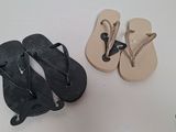 two pairs of flip flops on a white table