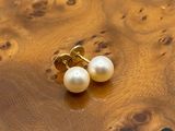 boucles d'oreilles à perles sur un support en bois