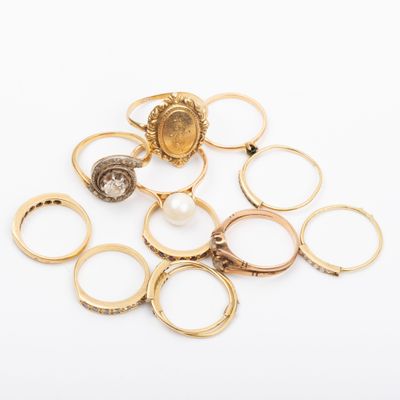une pile de bagues en or et une bague en perle