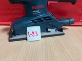 une ponceuse orbitale Black & Decker posée sur une table en bois