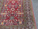 a red rug with a floral design on it