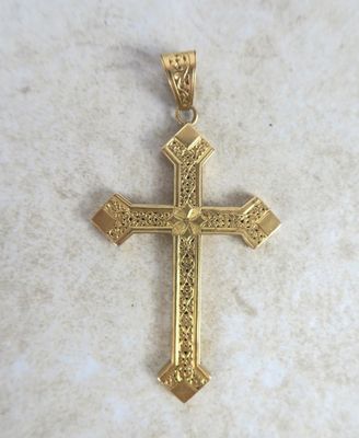 a close up of a gold cross on a marble surface