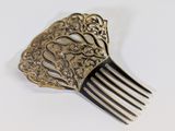a gold hair comb with an ornate design on it