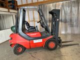 un chariot élévateur rouge garé à l'intérieur d'un bâtiment
