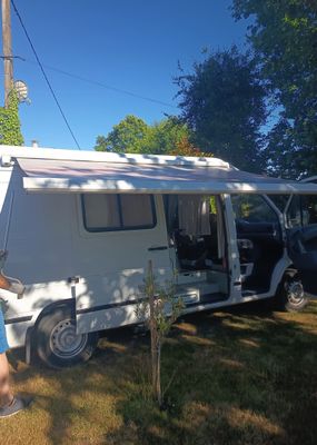 un homme qui se tient à côté d'un camping-car